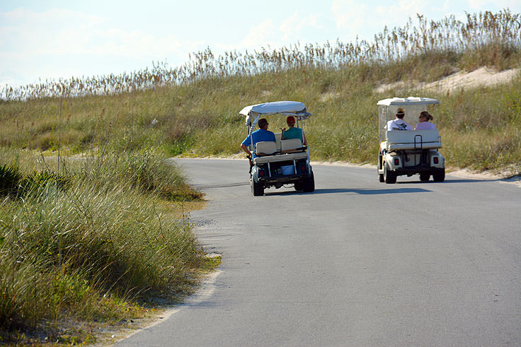 Golf carts pass each other on Bald Head Island, NC