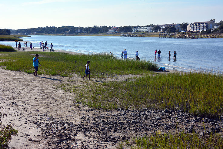 Families fish and play in the water at Ocean Isle Beach