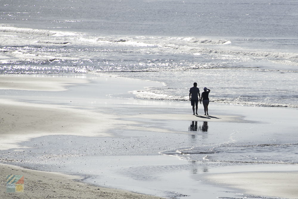 A couple strolls along Ocean Isle Beach