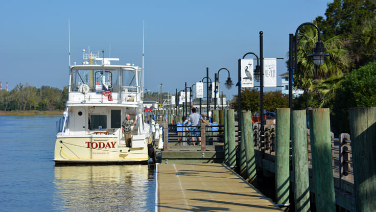 A boat docked at the Riverwalk in Wilmington, NC